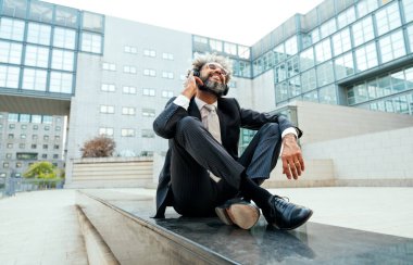 Genç girişimci iş adamı ofis dışında müzik dinleyip dans ediyor. İş hayatında özgürlük ve başarı kavramı