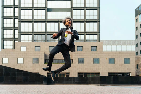 若い起業家は仕事で彼の成功した日を祝うためにジャンプして踊ります ビジネスキャリアにおける自由と屈託のない概念 — ストック写真