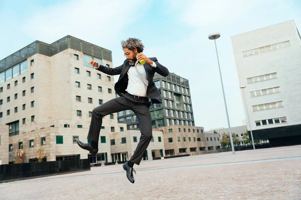 若い起業家は仕事で彼の成功した日を祝うためにジャンプして踊ります ビジネスキャリアにおける自由と屈託のない概念 — ストック写真