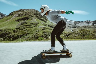 Sinema, yokuş aşağı uzun tahta seansı. Genç bir kadın kaykay yapıyor ve dağ geçidinde virajlar arasında numaralar yapıyor. Ekstrem sporlar ve insanlar hakkındaki kavram
