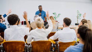 Bir konferans toplantısının sinematik görüntüsü. İş adamları bir odada oturup motivasyon koçunu dinliyor. Bir Öz Gelişim ve Gelişim Özel Olayının Temsili