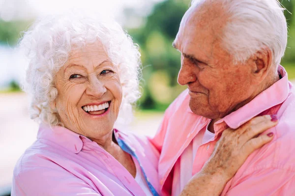 昔ながらのモダンなカップルはファッショナブルな色の服 若い祖母と祖父は屋外で楽しく野生になっています 中で若い感じの高齢者の表現 — ストック写真