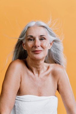 Image of a beautiful senior woman posing on a beauty photo session. Middle aged woman on a colored background. Concept about body positivity, self esteem and body acceptance clipart