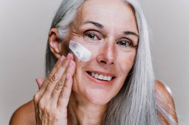 Güzellik fotoğrafında poz veren son sınıf güzel bir kadının görüntüsü. Renkli bir geçmişi olan orta yaşlı bir kadın. Vücut pozitifliği, kendine güven ve beden kabulü kavramları