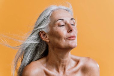 Güzellik fotoğrafında poz veren son sınıf güzel bir kadının görüntüsü. Renkli bir geçmişi olan orta yaşlı bir kadın. Vücut pozitifliği, kendine güven ve beden kabulü kavramları