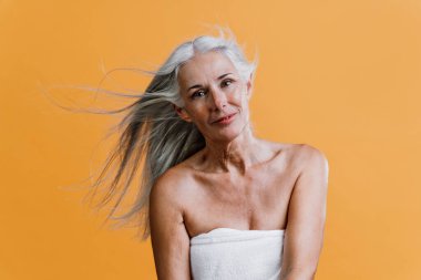 Güzellik fotoğrafında poz veren son sınıf güzel bir kadının görüntüsü. Renkli bir geçmişi olan orta yaşlı bir kadın. Vücut pozitifliği, kendine güven ve beden kabulü kavramları