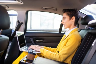 Şehirde kısa saçlı, güzel bir genç kadın beyaz, kadın, yetişkin, şık takım elbiseli bir iş kadını işe gidiyor.