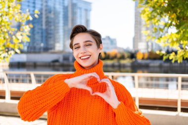 Şehirde kısa saçlı, güzel, beyaz, kadın, yetişkin iş kadını, kışlık süveter giyiyor.