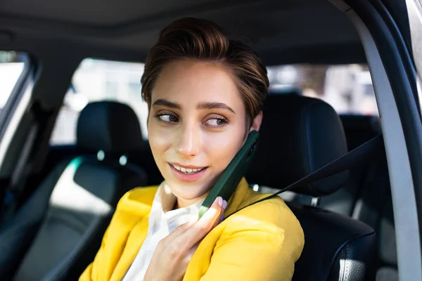 Beautiful young woman with short hair driving car in the city - Pretty caucasian female adult business woman wearing elegant suit going to work in the office