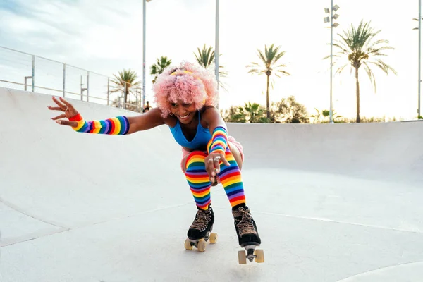 stock image Beautiful woman skating with roller skates and having fun. Professional skater and dancer training in the morning wearing colored and fashionable clothes.