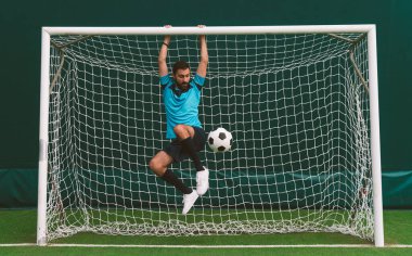 Futbol serbest stil oyuncusunun suni çim kortunda top oynarken çekilmiş sinematik bir görüntüsü. Spor ve insan yaşam tarzı kavramı