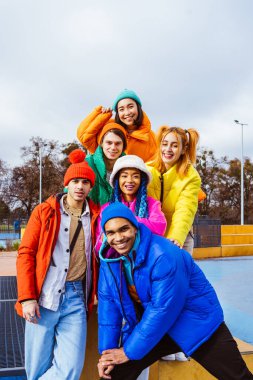 Kışın dışarıda buluşan, kışlık ceketler giyen ve eğlenen çok ırklı genç arkadaşlardan oluşan çok ırklı bir grup kentsel alanda kaynaşıyor. Gençlik ve sosyal rahatlama kavramları.