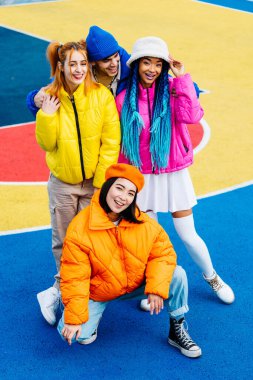 Kışın dışarıda buluşan, kışlık ceketler giyen ve eğlenen çok ırklı genç arkadaşlardan oluşan çok ırklı bir grup kentsel alanda kaynaşıyor. Gençlik ve sosyal rahatlama kavramları.