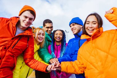 Kışın dışarıda buluşan, kışlık ceketler giyen ve eğlenen çok ırklı genç arkadaşlardan oluşan çok ırklı bir grup kentsel alanda kaynaşıyor. Gençlik ve sosyal rahatlama kavramları.