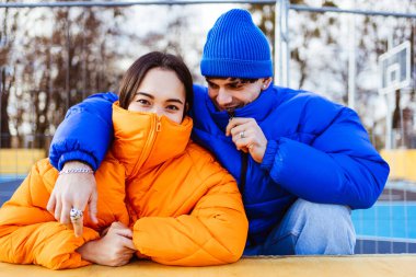 Kışın açık havada buluşan, kışlık ceketler giyen ve eğlenen çok ırklı genç aşıklar. Kentsel alanda çok ırklı binyıllar, gençlik ve sosyal rahatlama kavramları.