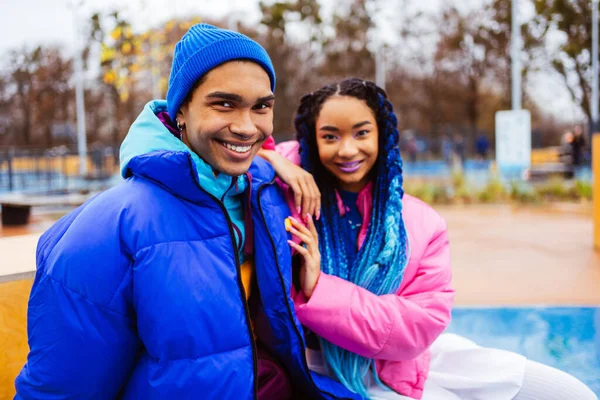 Multiracial young couple of lovers dating outdoors in winter, wearing winter jackets and having fun - Multiethnic millennials bonding in a urban area, concepts about youth and social releationships