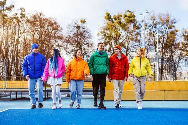 Multiracial group of young happy friends meeting outdoors in winter, wearing winter jackets and having fun - Multiethnic millennials bonding in a urban area, concepts about youth and social releationships