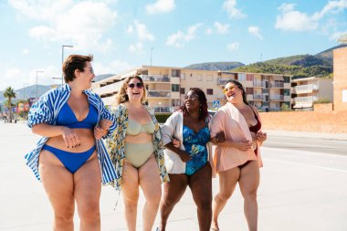 Group of beautiful plus size women with swimwear bonding and having fun at the beach - Group of curvy female friends enjoying summertime at the sea, concepts about body acceptance, body positive and self confidence
