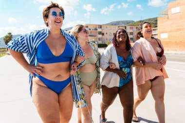 Group of beautiful plus size women with swimwear bonding and having fun at the beach - Group of curvy female friends enjoying summertime at the sea, concepts about body acceptance, body positive and self confidence