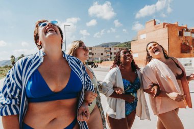 Group of beautiful plus size women with swimwear bonding and having fun at the beach - Group of curvy female friends enjoying summertime at the sea, concepts about body acceptance, body positive and self confidence