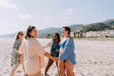 Group of beautiful plus size women with swimwear bonding and having fun at the beach - Group of curvy female friends enjoying summertime at the sea, concepts about body acceptance, body positive and self confidence