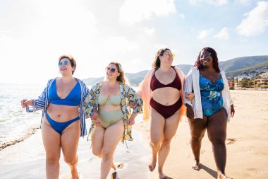 Group of beautiful plus size women with swimwear bonding and having fun at the beach - Group of curvy female friends enjoying summertime at the sea, concepts about body acceptance, body positive and self confidence