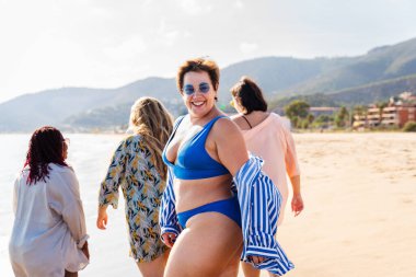 Group of beautiful plus size women with swimwear bonding and having fun at the beach - Group of curvy female friends enjoying summertime at the sea, concepts about body acceptance, body positive and self confidence