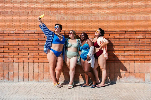 美しいプラスサイズの女性のグループは 水着ボンディングとビーチで楽しみを持っています レンガの壁の背景にポーズ 海で夏を楽しんで曲線的な女性の友人 体の受け入れについての概念 体の正と自信 — ストック写真