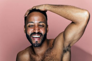 Tenine bakan genç bir adamın görüntüsü. Güzellik stüdyosu cilt bakımı ve kişisel hijyen ürünleri hakkında çekim yapıyor..