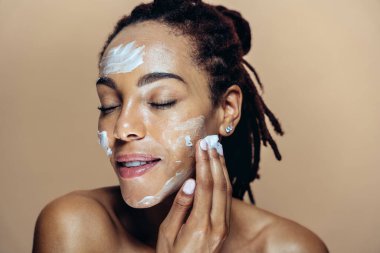 Güzel bir kadın cilt ve yüz bakımı yapıyor. Kozmetik ve cilt bakımı konseptlerine odaklı stüdyo çekimi