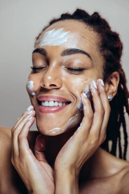 Güzel bir kadın cilt ve yüz bakımı yapıyor. Kozmetik ve cilt bakımı konseptlerine odaklı stüdyo çekimi