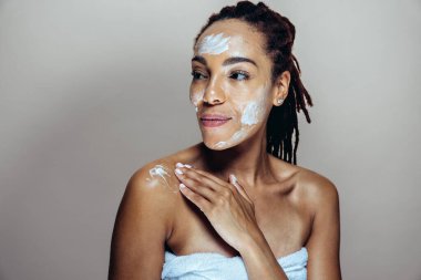 Güzel bir kadın cilt ve yüz bakımı yapıyor. Kozmetik ve cilt bakımı konseptlerine odaklı stüdyo çekimi
