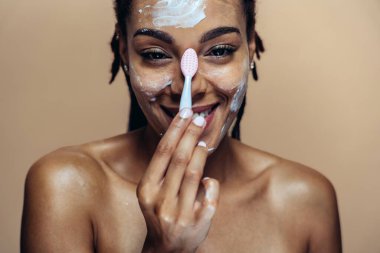 Güzel bir kadın cilt ve yüz bakımı yapıyor. Kozmetik ve cilt bakımı konseptlerine odaklı stüdyo çekimi