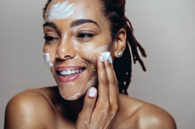 Güzel bir kadın cilt ve yüz bakımı yapıyor. Kozmetik ve cilt bakımı konseptlerine odaklı stüdyo çekimi