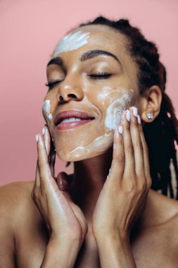 Güzel bir kadın cilt ve yüz bakımı yapıyor. Kozmetik ve cilt bakımı konseptlerine odaklı stüdyo çekimi