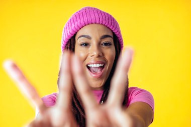 Renkli arka planda poz veren güzel bir genç kadın. Renkli kıyafetler giyiyor. Tasasız, moda ve yaşam tarzı kavramları