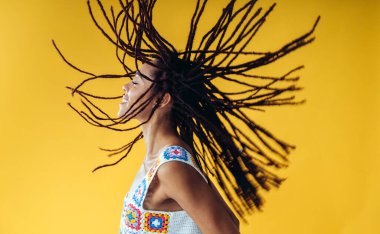 Renkli arka planda poz veren güzel bir genç kadın. Renkli kıyafetler giyiyor. Tasasız, moda ve yaşam tarzı kavramları