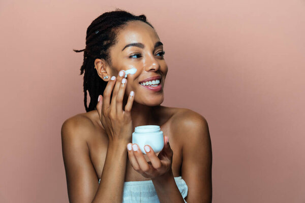 Beautiful woman making skin and facial beauty treatments. Studio shot with focus on cosmetic and skin care concepts