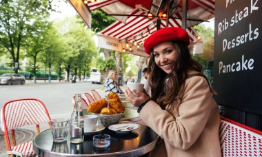 Beautiful young woman visiting paris and the eiffel tower. Parisian girl with red hat and fashionable clothes having fun in the city center and landmarks area