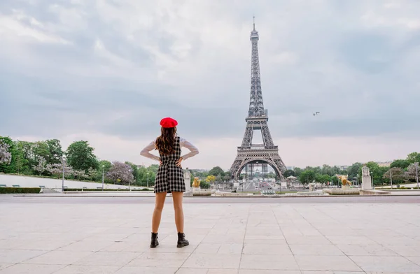 パリとエッフェル塔を訪れる美しい若い女性 赤い帽子とファッショナブルな服を持つパリの女の子は 市内中心部やランドマークエリアで楽しんでいます — ストック写真