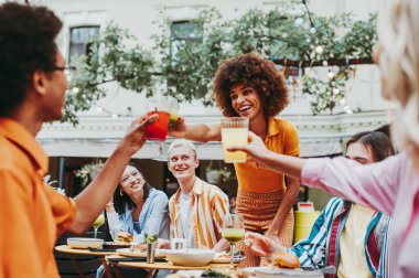 Multiracial young people together meeting and having party in a restaurant - Group of friends with mixed races having fun celebrating in a bar- Friendship and lifestyle concepts