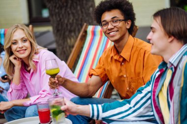 Multiracial young people together meeting and having party in a restaurant - Group of friends with mixed races having fun celebrating in a bar- Friendship and lifestyle concepts