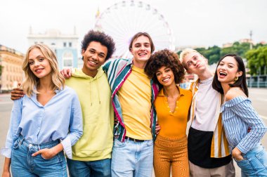 Multiracial young people together meeting and social gathering - Group of friends with mixed races having fun outdoors in the city- Friendship and lifestyle concepts