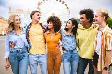 Multiracial young people together meeting and social gathering - Group of friends with mixed races having fun outdoors in the city- Friendship and lifestyle concepts