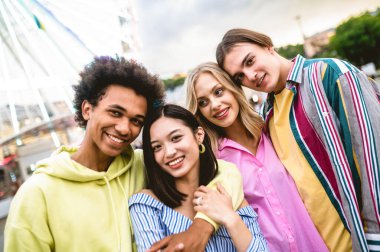 Multiracial young people together meeting and social gathering - Group of friends with mixed races having fun outdoors in the city- Friendship and lifestyle concepts