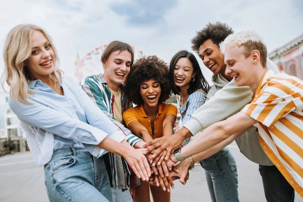 Multiracial young people together meeting and social gathering - Group of friends with mixed races having fun outdoors in the city- Friendship and lifestyle concepts