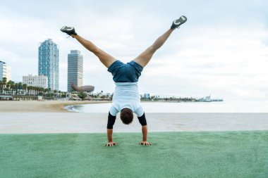 Sportive and athletic man doing functional training exercise at the outdoor gym - Adult athlete doing workout at sunrise at calisthenics park on the beach - Fitness, healthy lifestyle and sport concepts