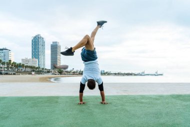 Sportive and athletic man doing functional training exercise at the outdoor gym - Adult athlete doing workout at sunrise at calisthenics park on the beach - Fitness, healthy lifestyle and sport concepts