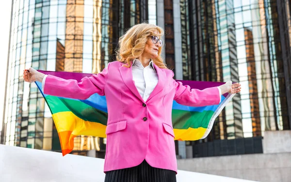 Transgender business woman lifestyle moments in downtown, Los angeles. Transgender woman holding a rainbow  flag and standing for the lgbt community rights at a public manifestation