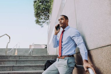Handsome male african american business man CEO in a stylish corporate elegant suit in a business center outdoors - Black male commuter going to work, city and financial district in the background